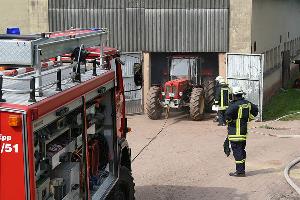 Bild: Ein Traktor muss mit der Seilwinde des R&amp;uuml;stwagens aus der verqualmten Halle gezogen werden, um freien Zugang zu den R&amp;auml;umlichkeiten zu erhalten
