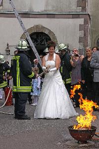 Bild: Die Braut beim L&amp;ouml;schen des Brandes mit einer K&amp;uuml;belspritze