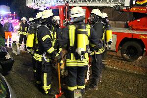 Bild: Mit Atemschutz ausger&amp;uuml;stete Feuerwehrleute warten auf ihren Einsatz